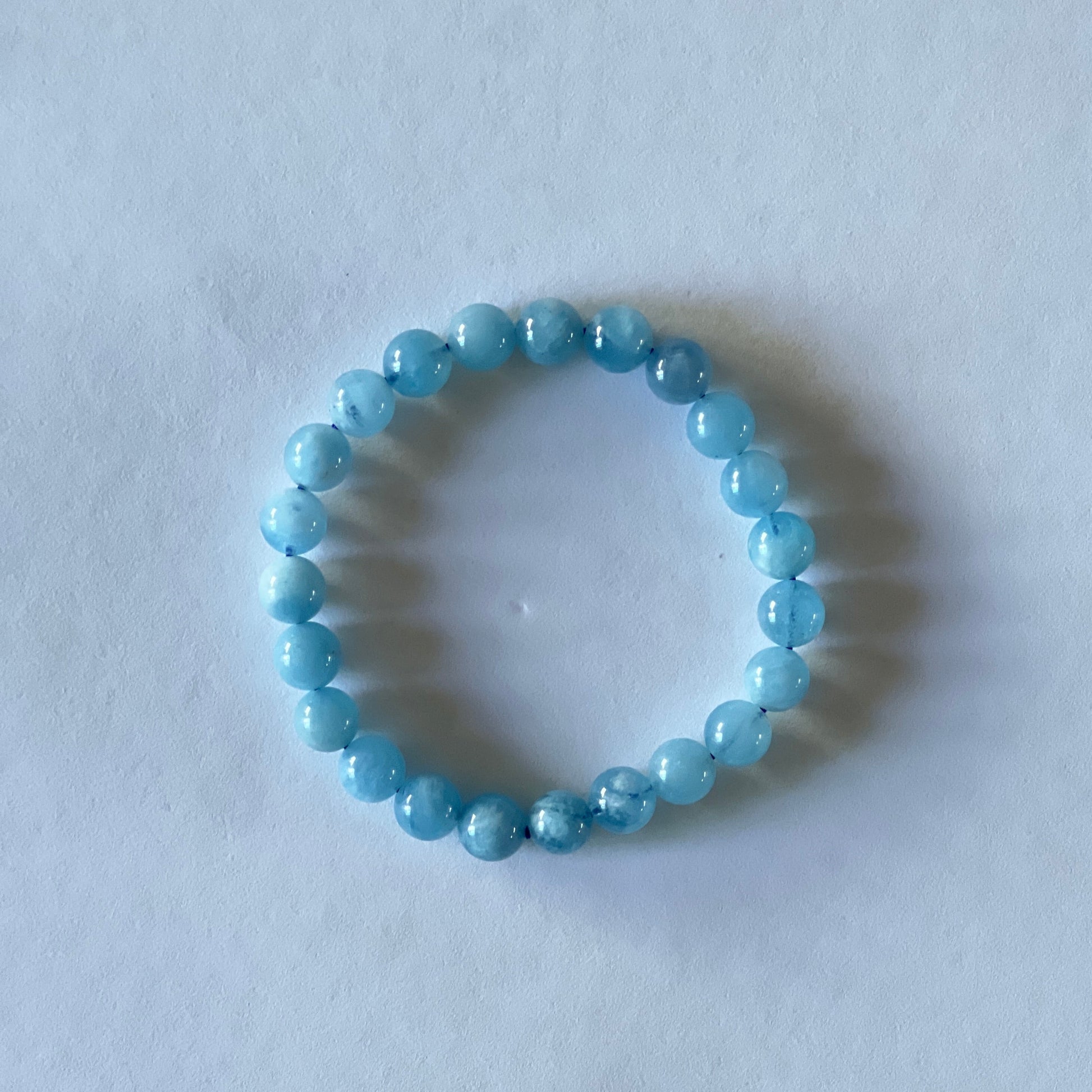 aquamarine beaded bracelet on a light gray background